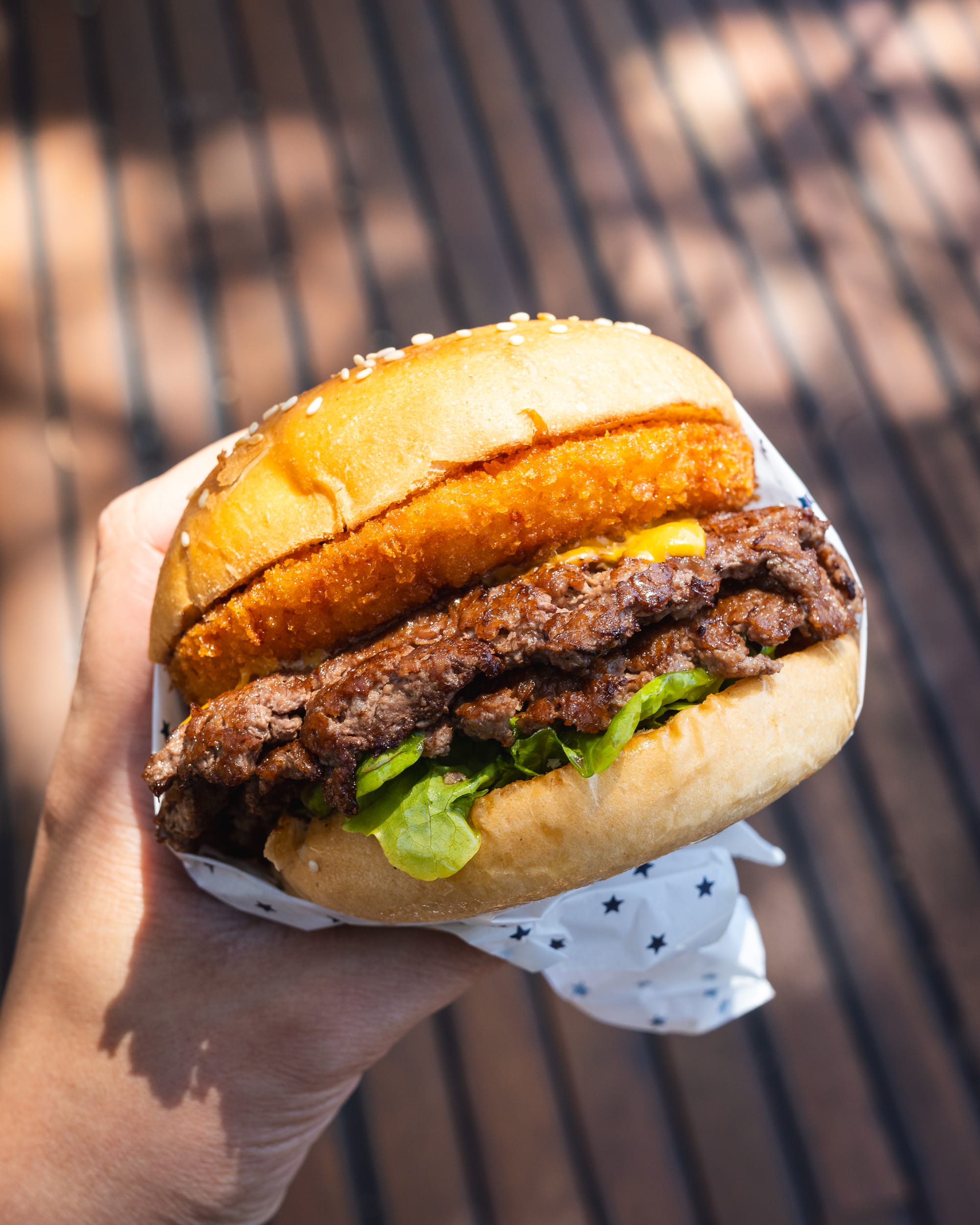 Hand holding double beef burger