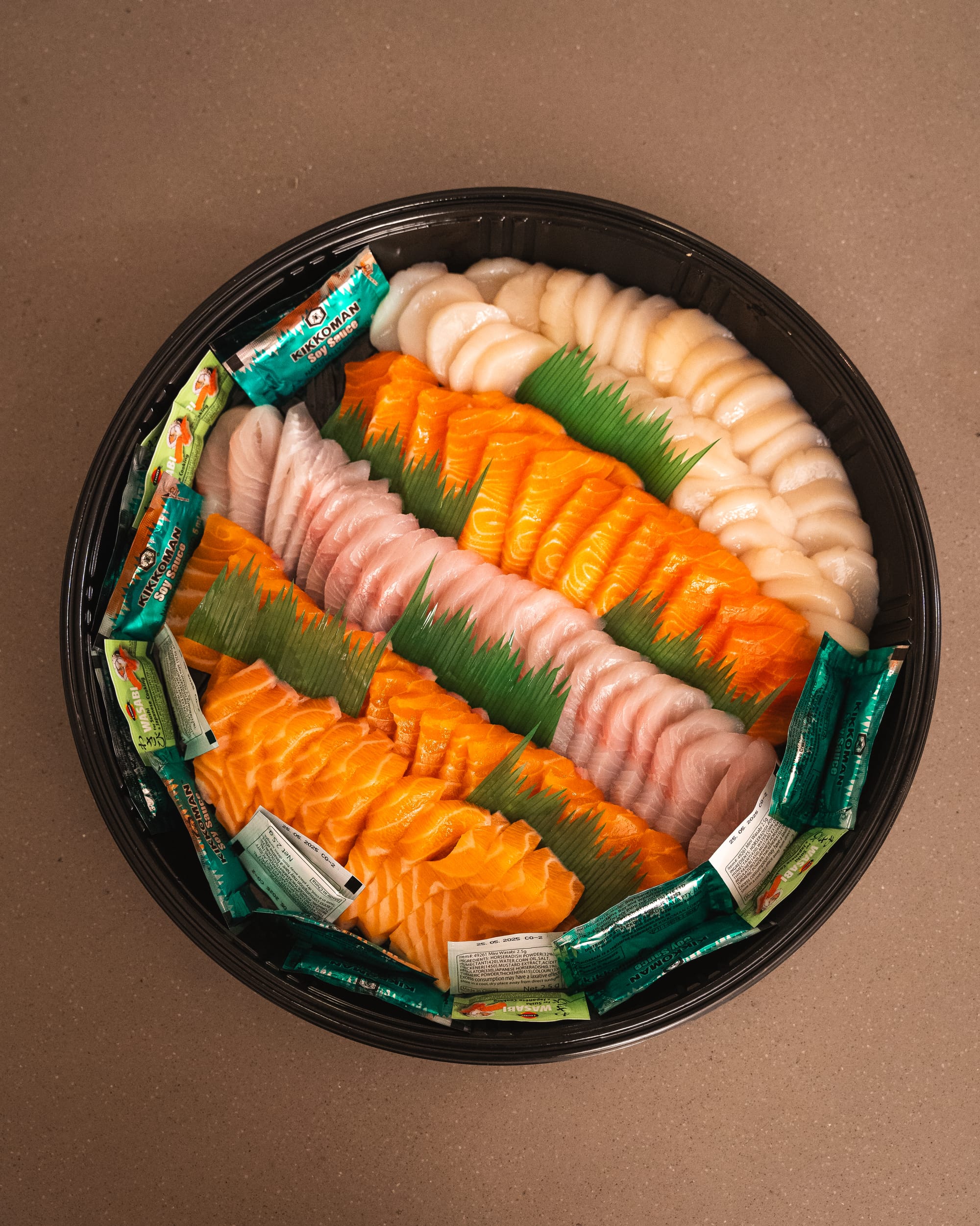 Top down shot of sashimi platter with salmon, kingfish, scallop and ocean trout