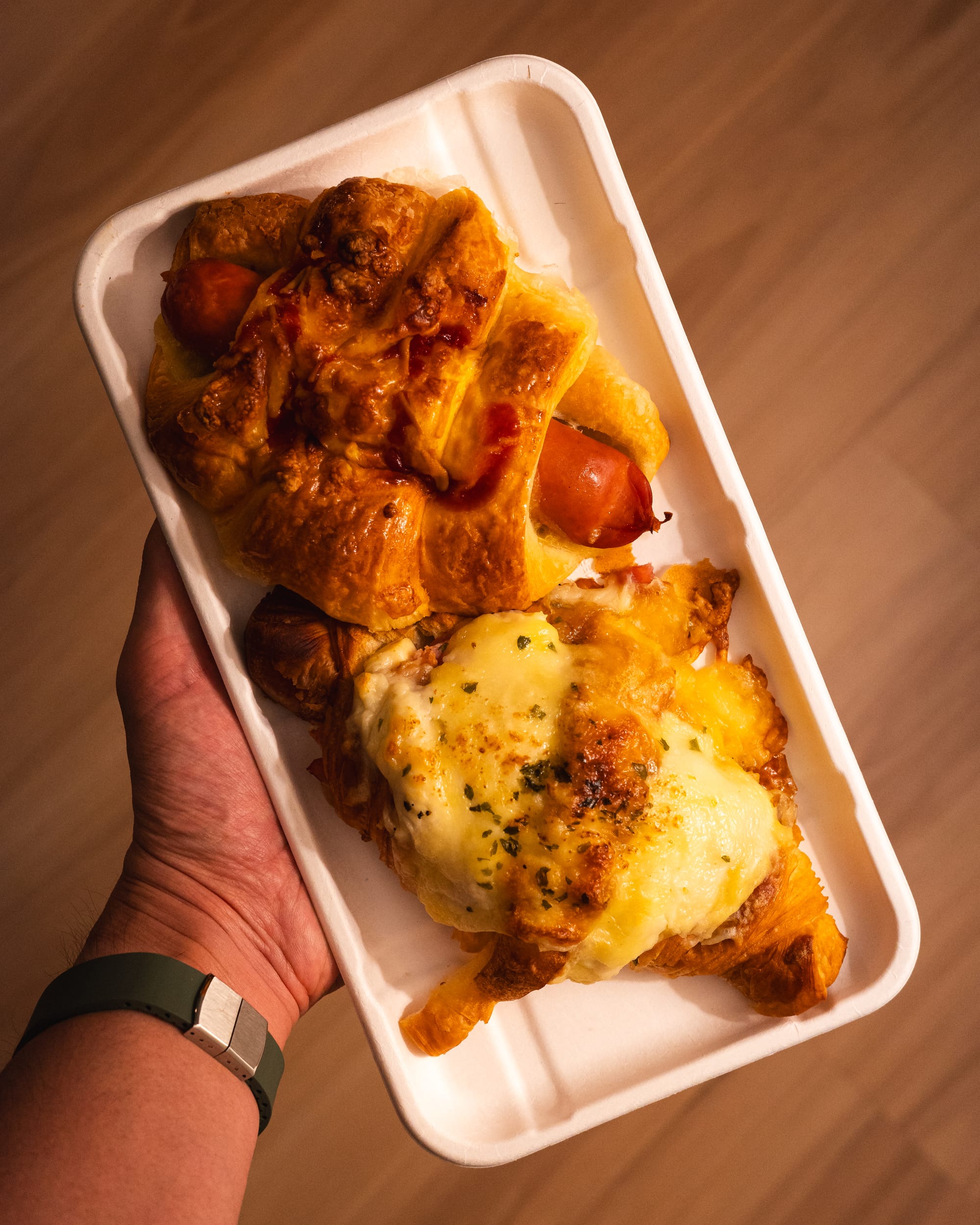 Top down shot of sausage bun and cheese croissant 