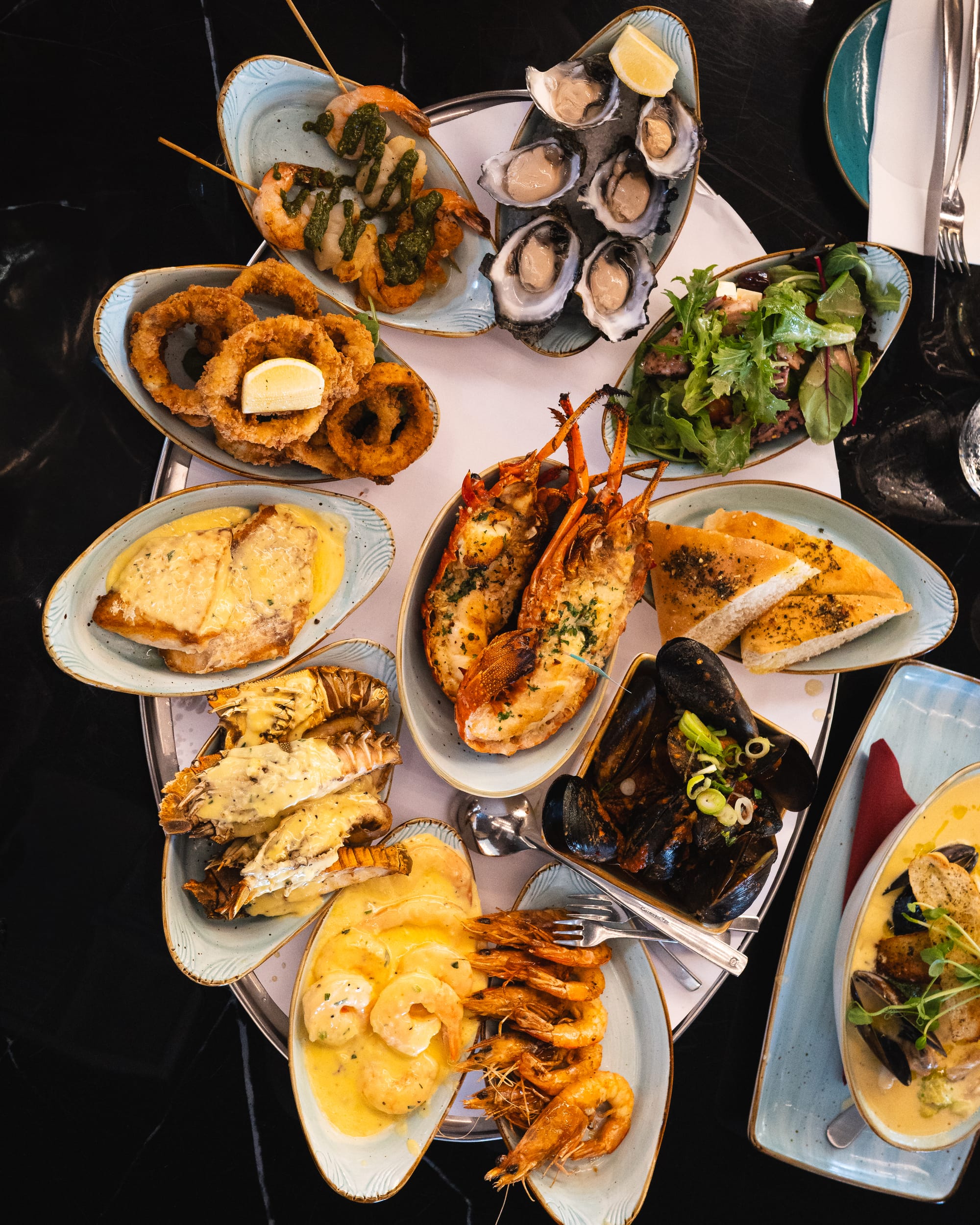 Top down shot of seafood platter with shellfish and salad and bread