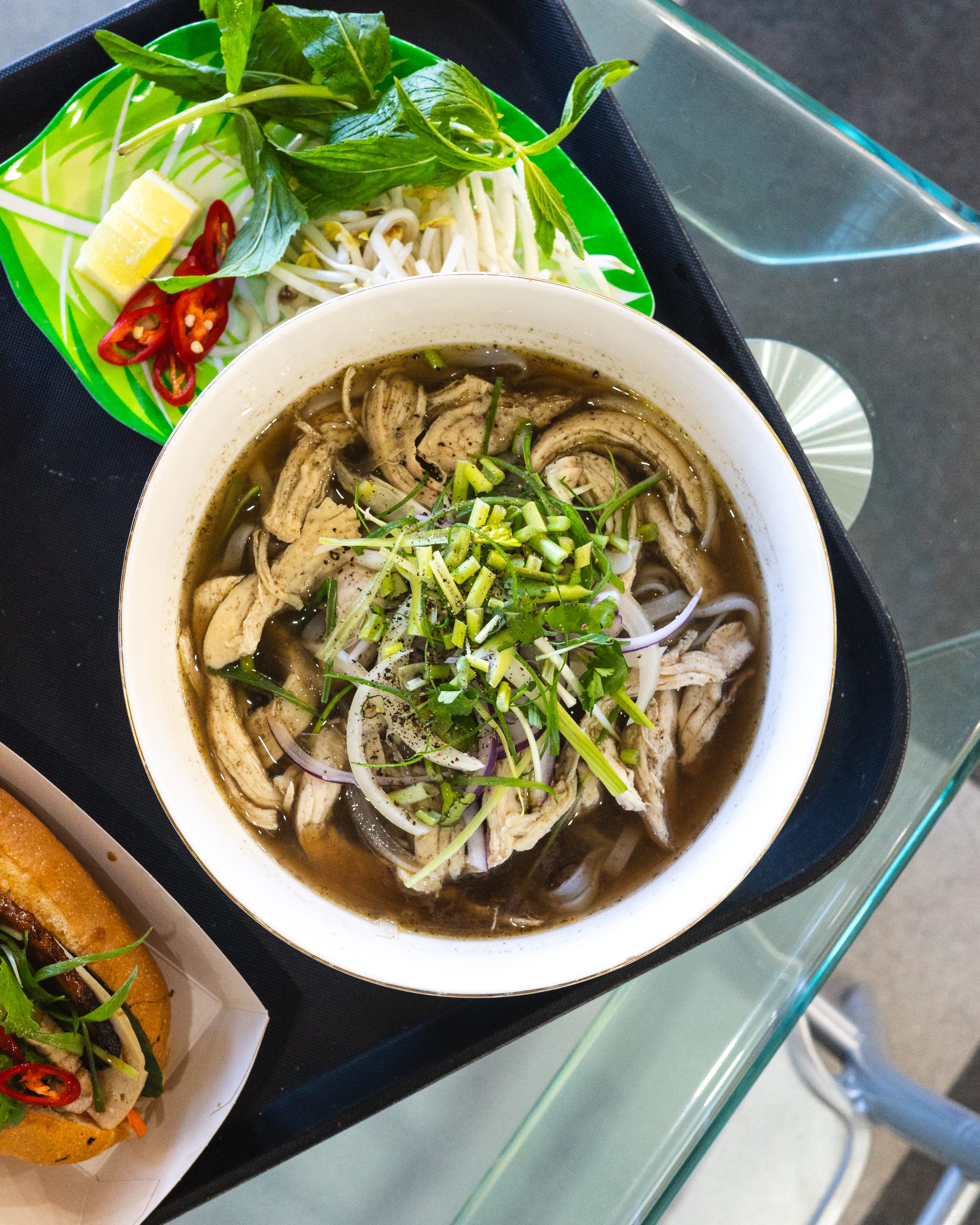 Top down shot of pho garnished with spring onions and coriander