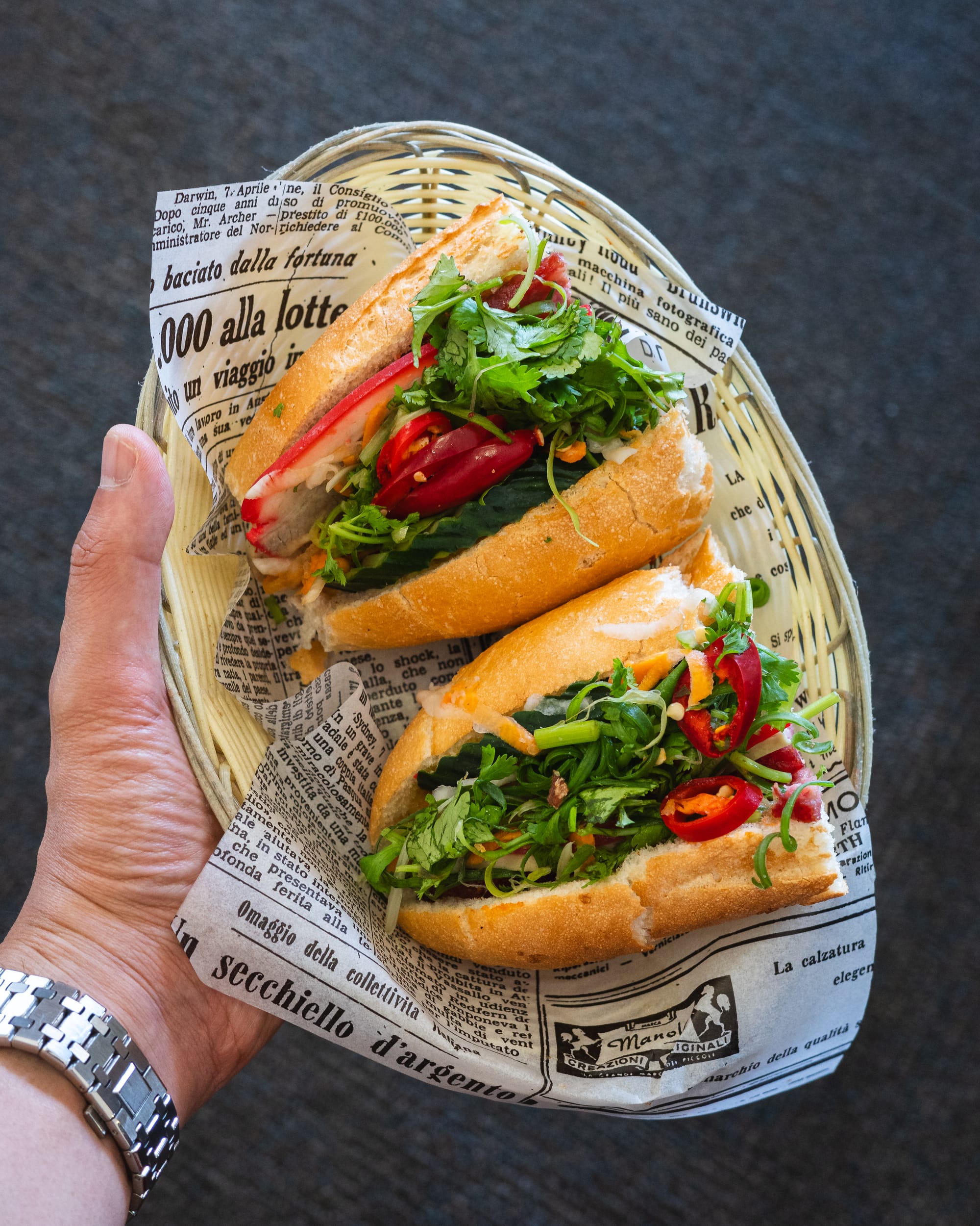 Hand holding banh mi cut open