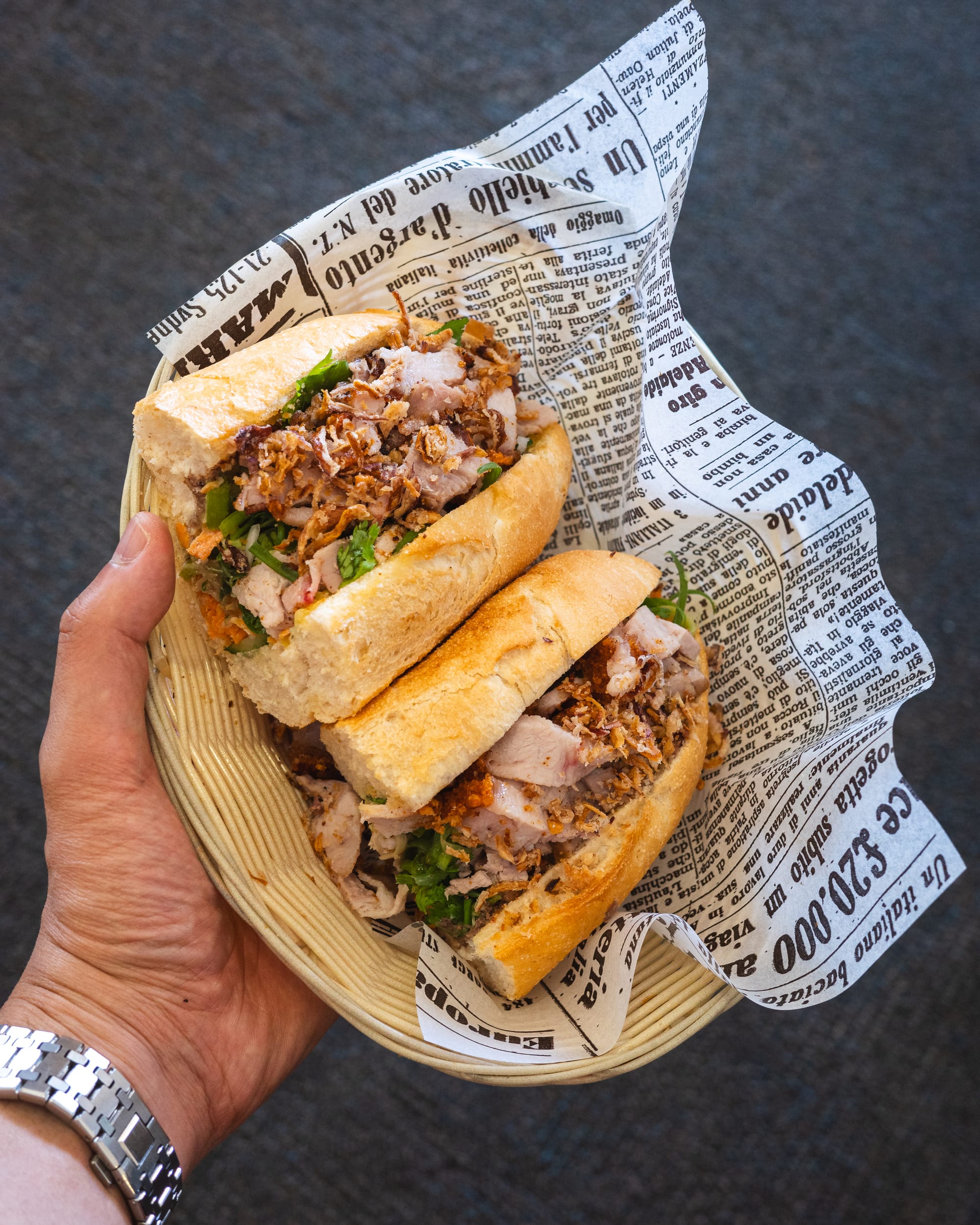 Hand holding banh mi cut open