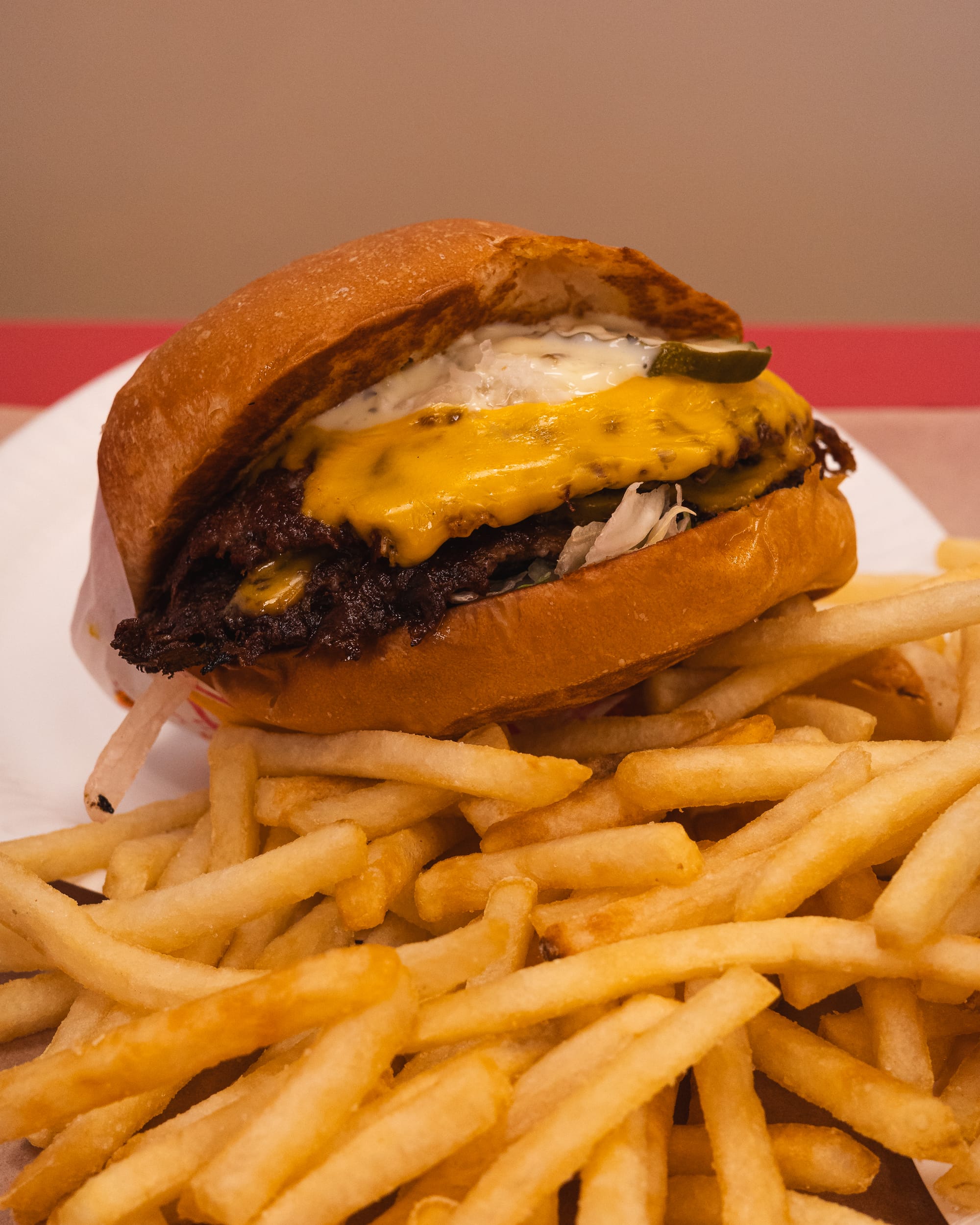 Cheeseburger with fries on a plate, featuring a juicy beef patty and melted cheese.