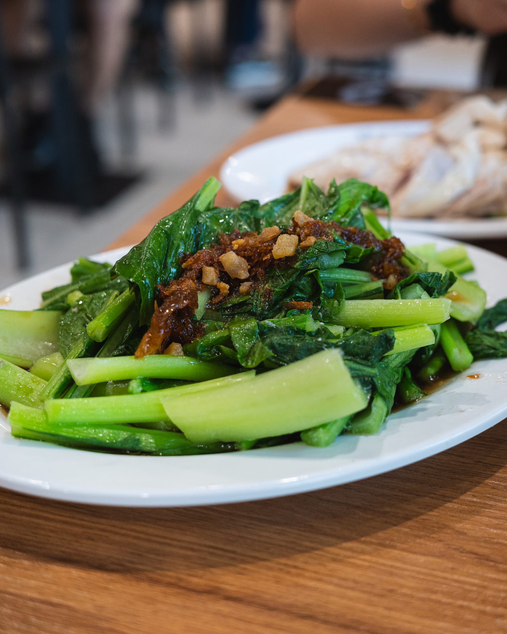 Stir-fried greens with garlic served on a white plate.