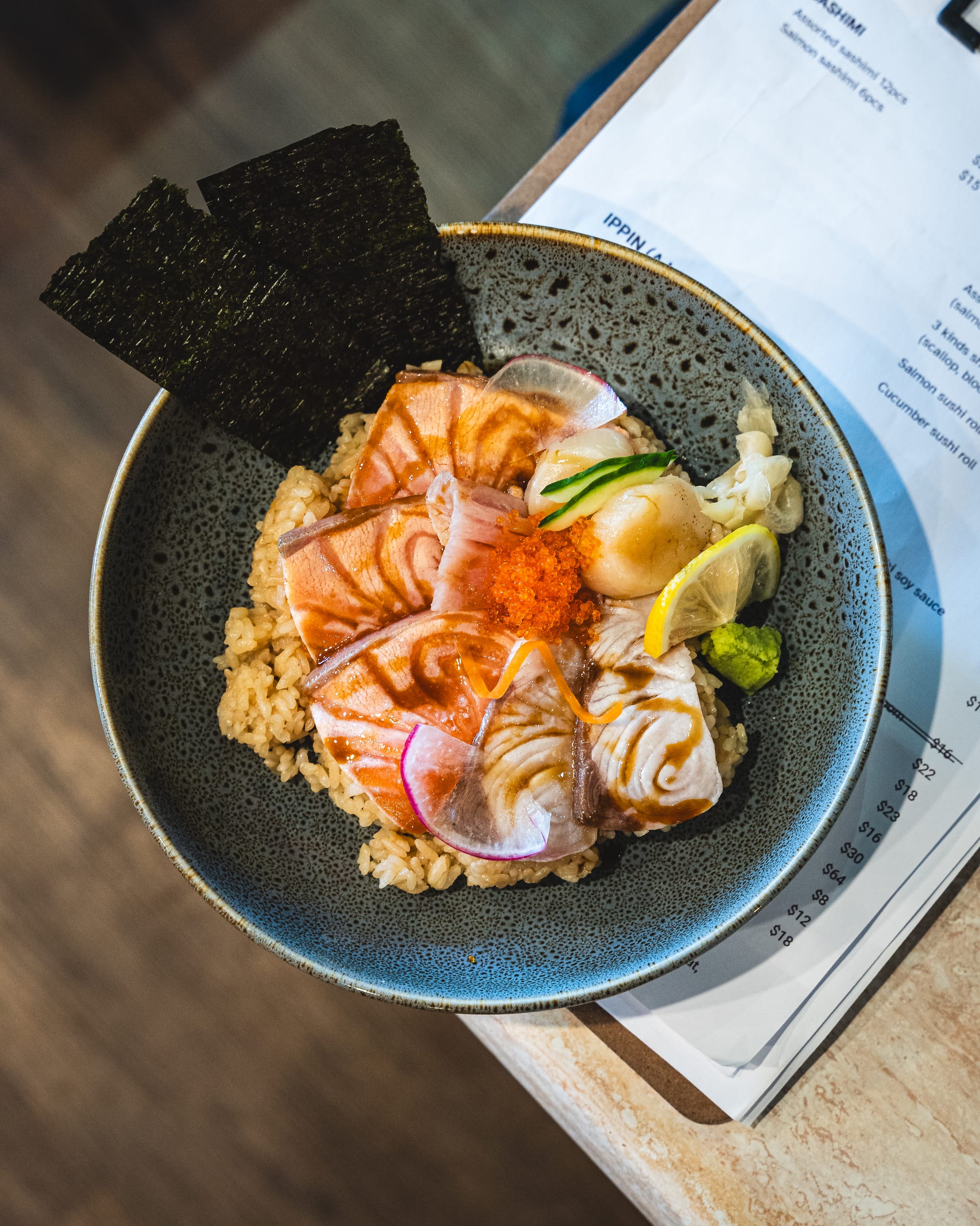 Chirashi bowl with assorted sashimi, rice, and seaweed crisps.