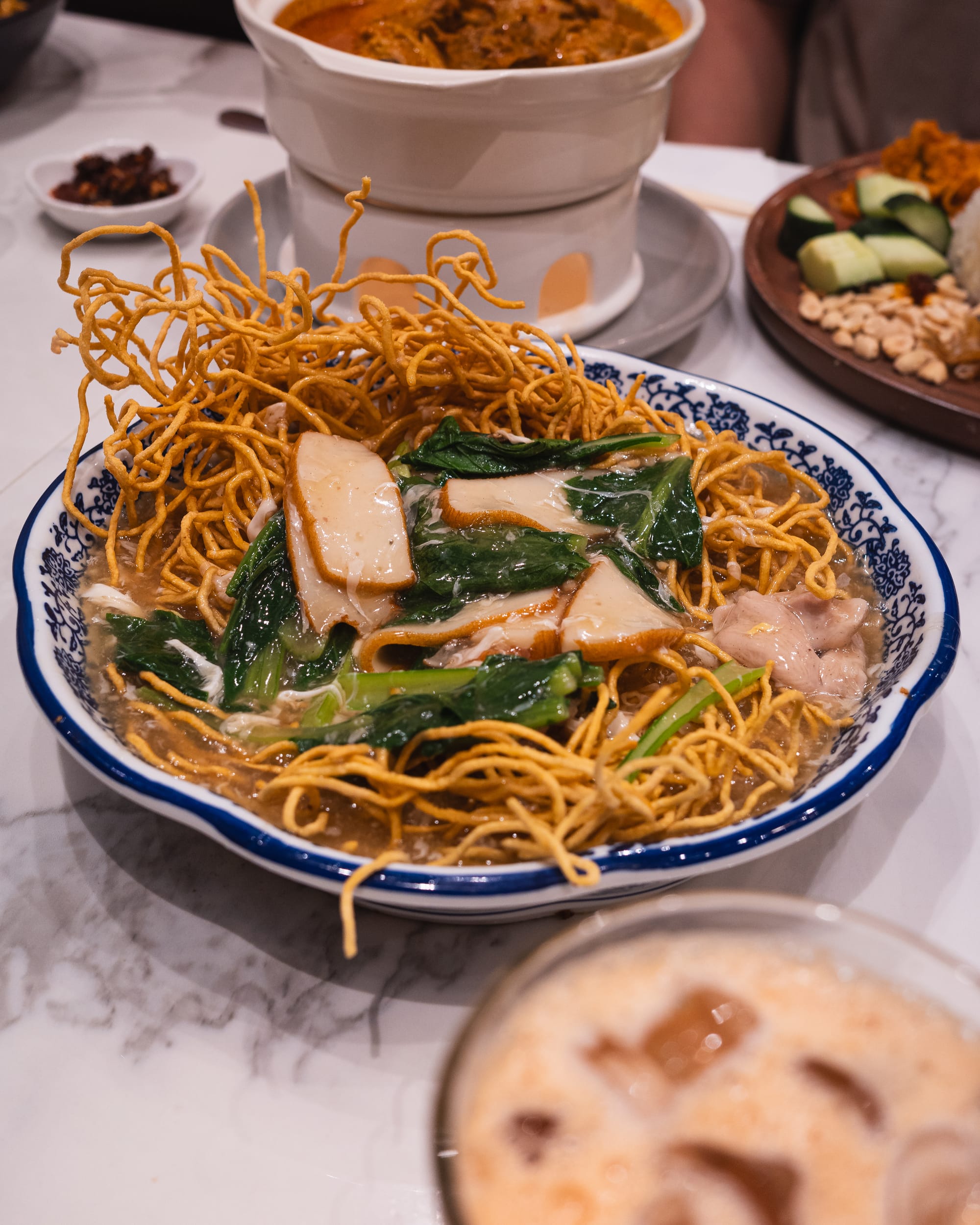 Bowl of crispy noodlesa with chicken and fresh greens