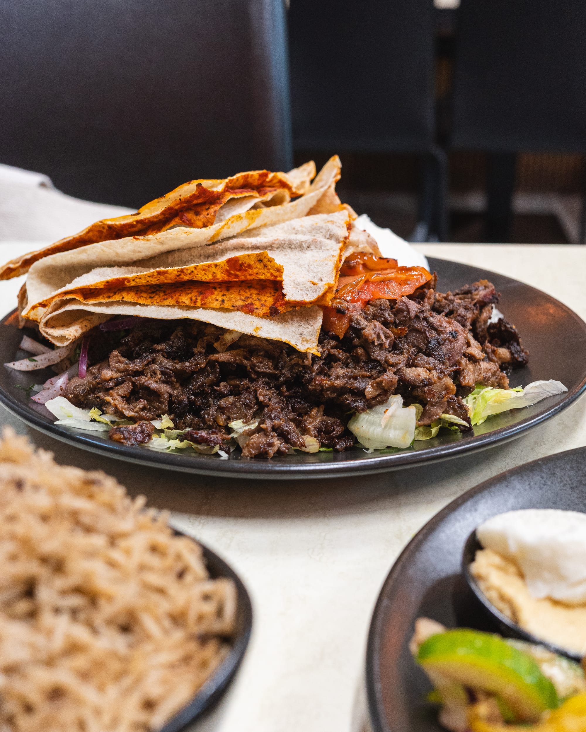 A Middle Eastern-inspired dish featuring grilled meat, flatbread, and a side of rice.