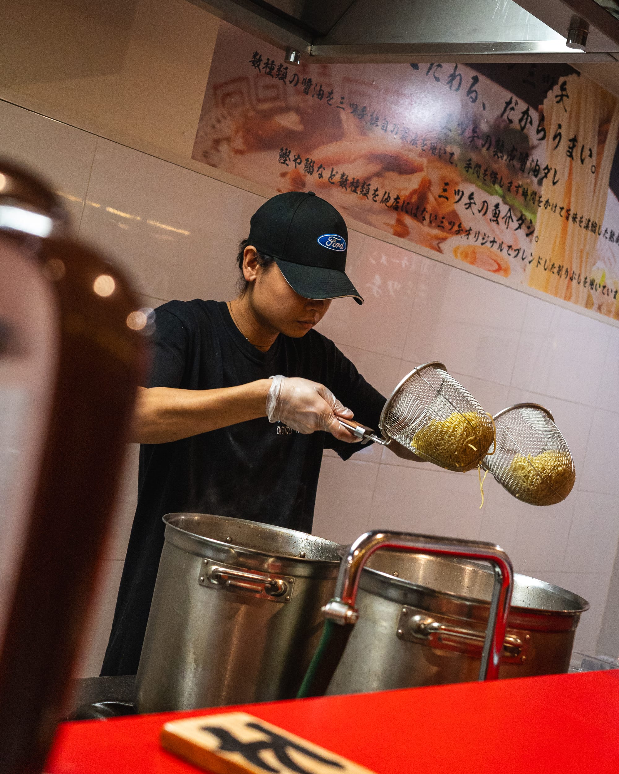 Chef shaking off extra water from ramen noodles