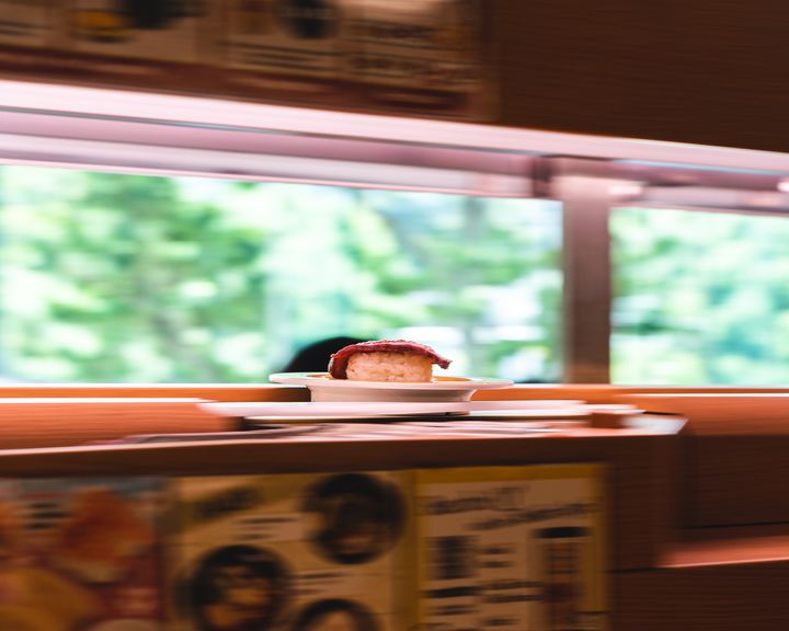 A panning shot of sushi on a conveyor belt