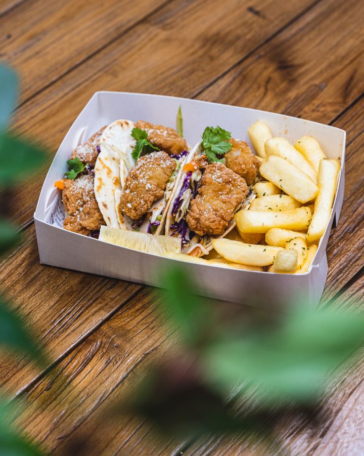 Close up of fish tacos with fries