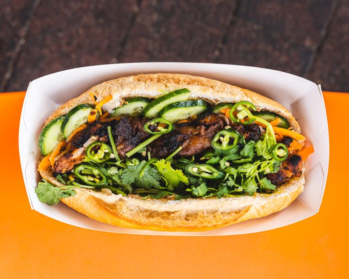 Top down shot of banh mi with grilled chicken, coriander and chilli