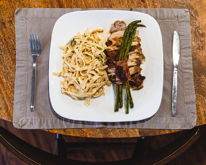 Top down shot of pasta on a plate, with cutlery on each side 