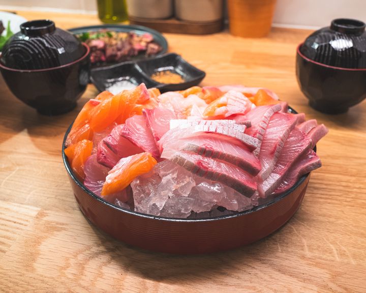 Close up oalmon, kingfish and scallop sashimi sitting on a bed of ice